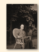 Charles Ives in 1950, zittend in het groen van zijn zomerhuis te West Redding, Connecticut